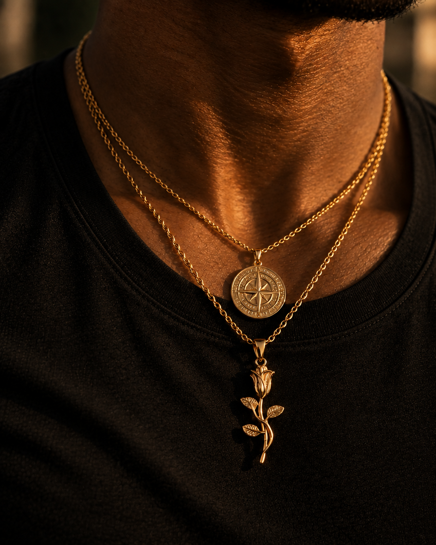 Compass- og The Rose-vedhæng i guld båret over sort t-shirt