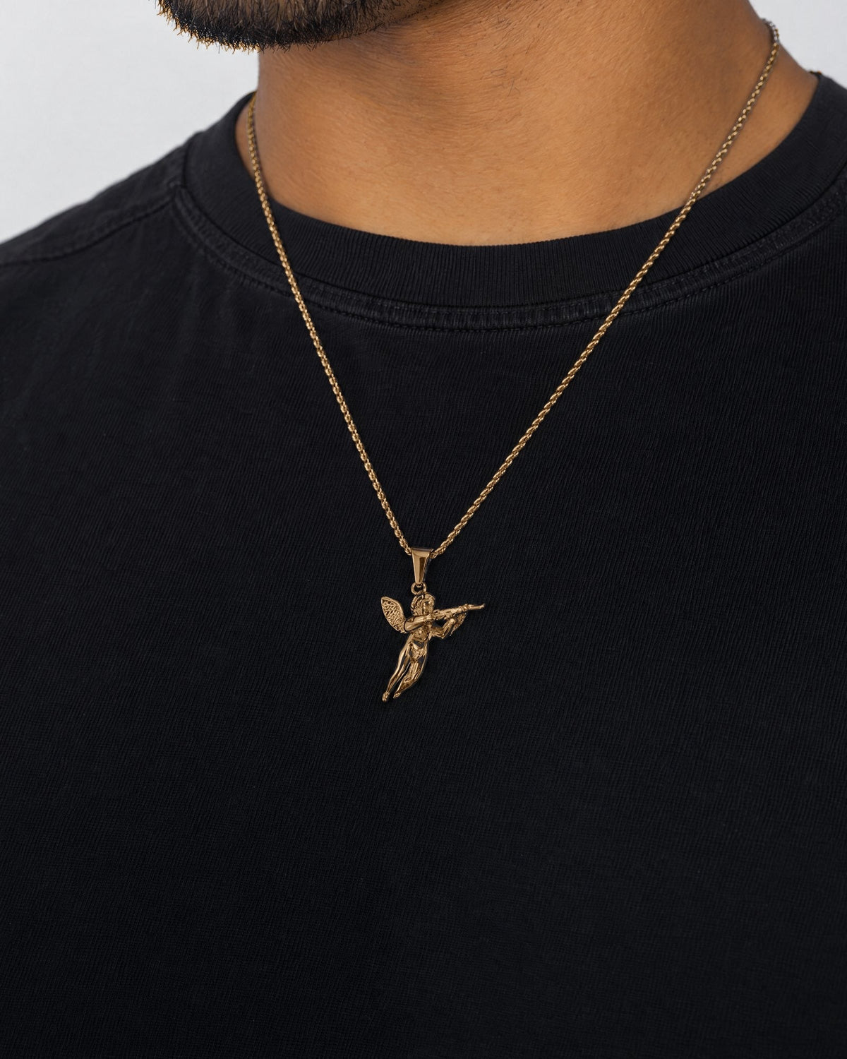 Mand i sort t-shirt med Angel 47-vedhæng i guld, set fra siden