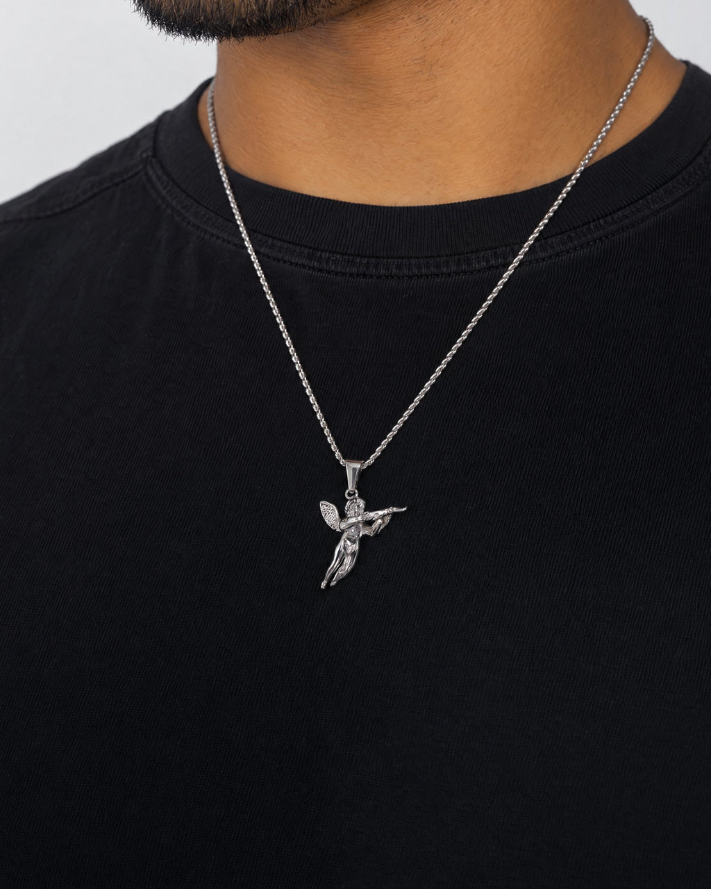 Mand i sort t-shirt med Angel 47-vedhæng i sølv, set fra siden