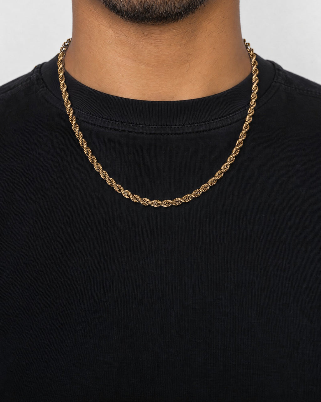 Mand i sort t-shirt med rope-kæde i guld, set forfra