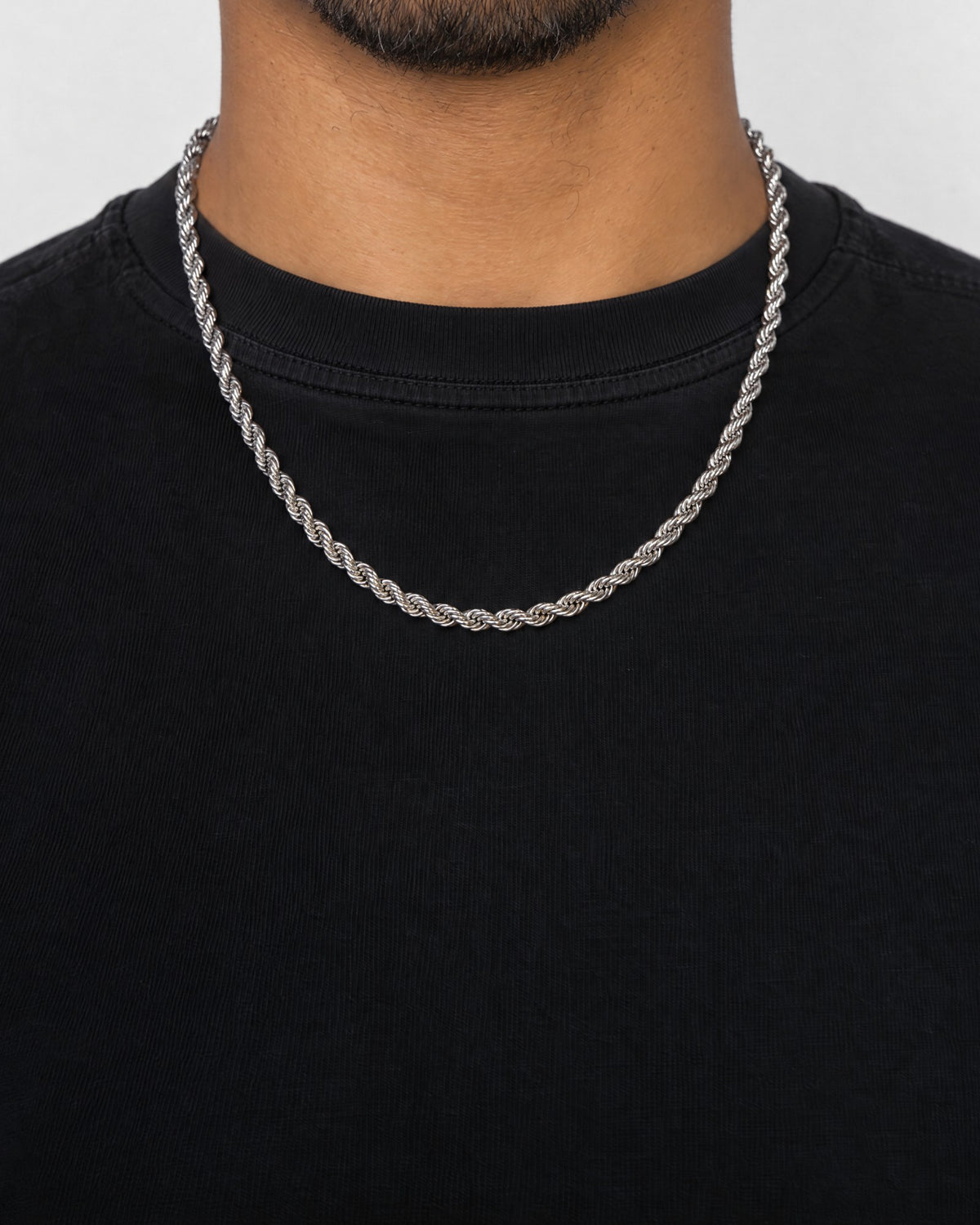 Mand i sort t-shirt med rope-kæde i sølv, set forfra