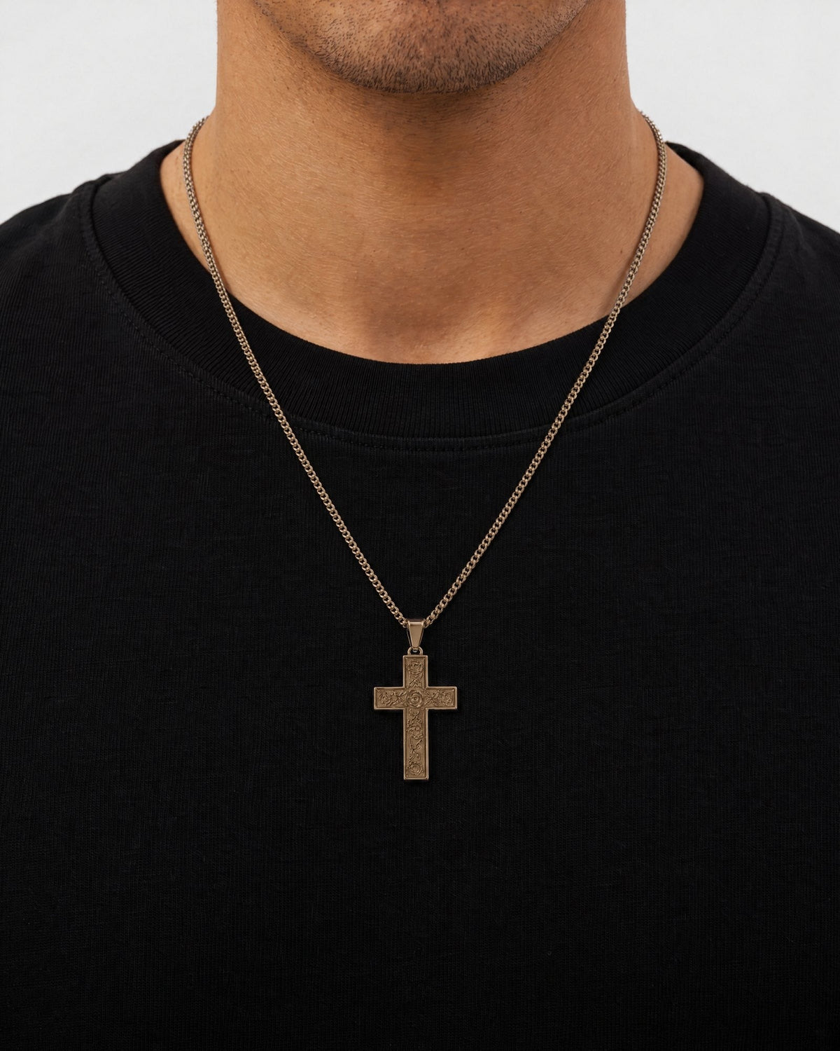 Mand i sort t-shirt med The Holy Cross-vedhæng i guld, set forfra