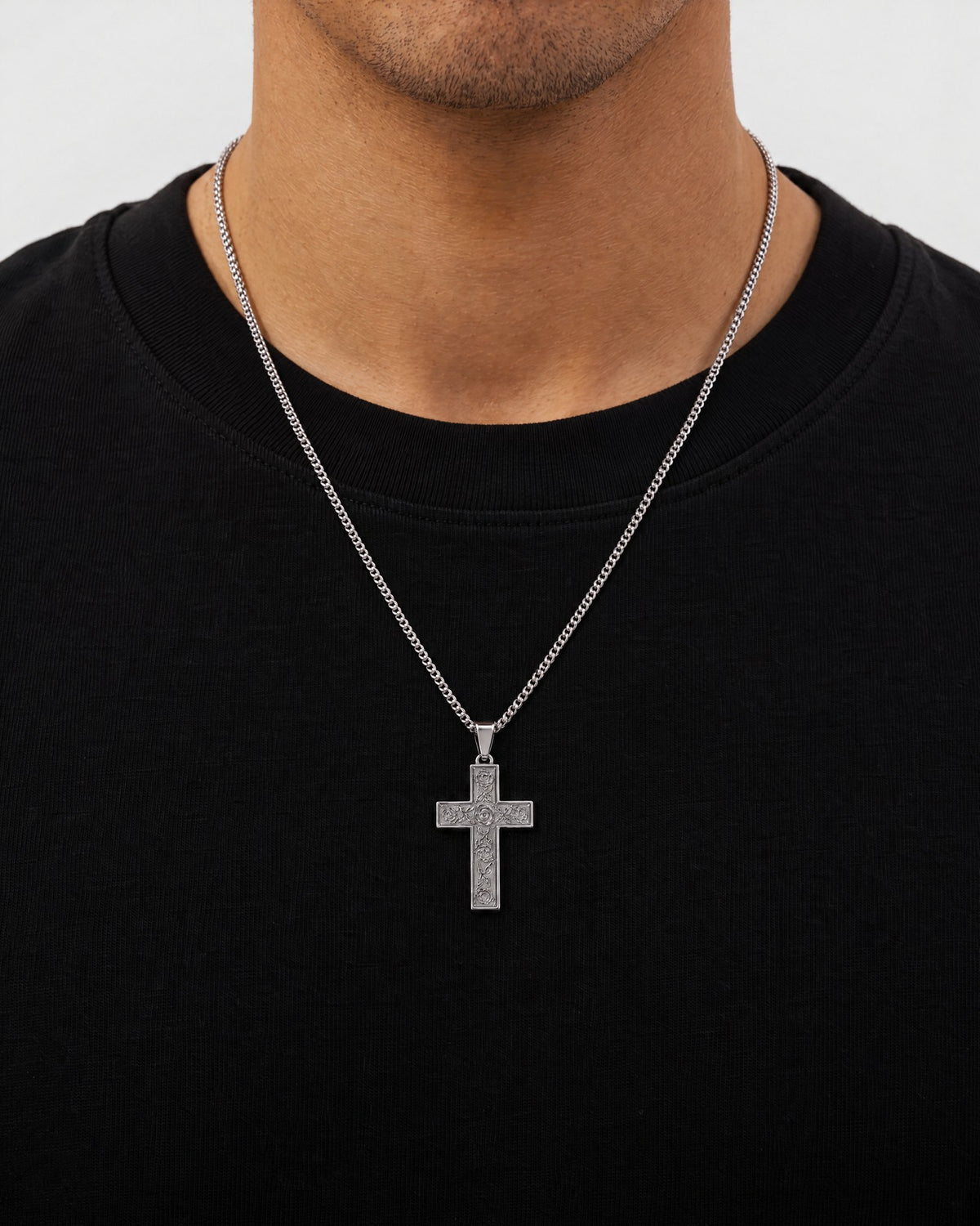Mand i sort t-shirt med The Holy Cross-vedhæng i sølv, set forfra