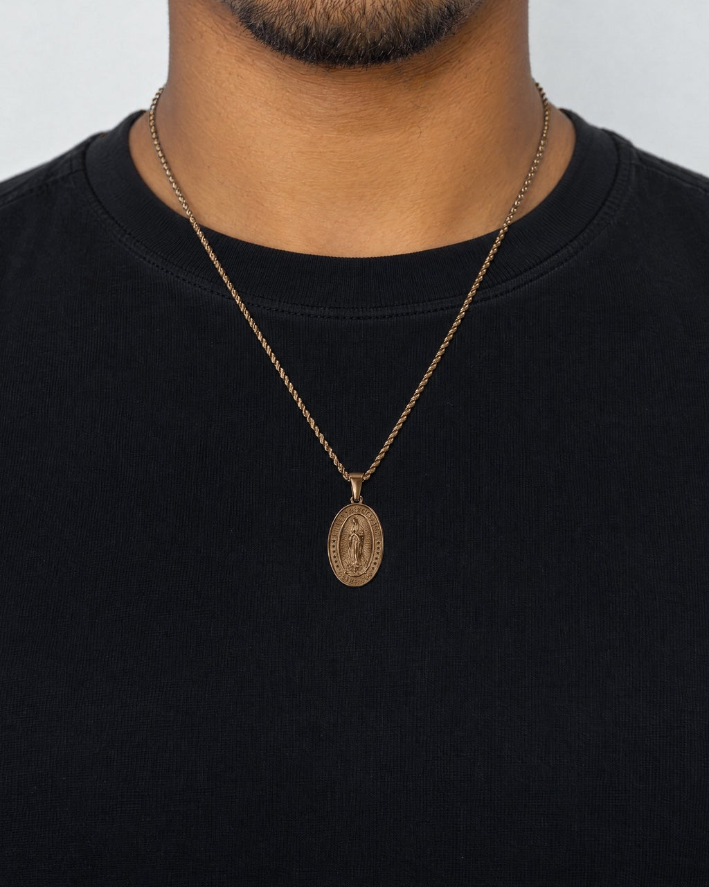 Mand i sort t-shirt med Virgin Mary-vedhæng i guld, set forfra