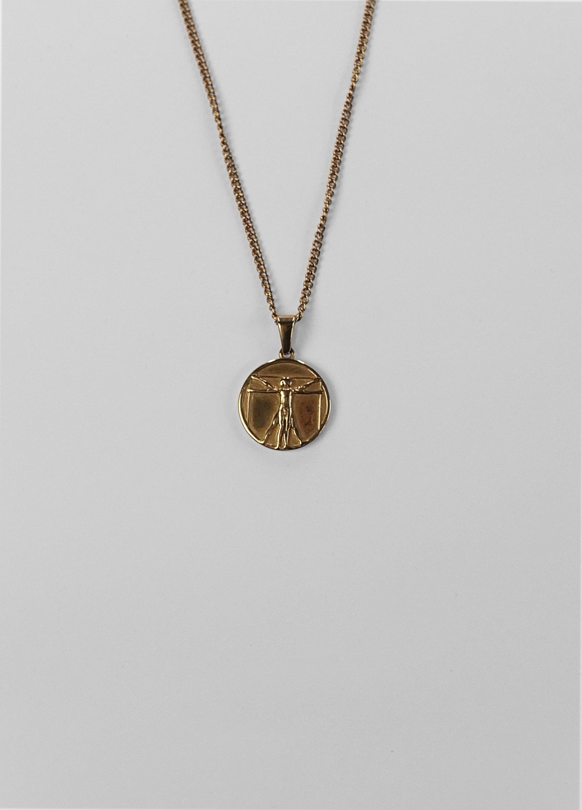 Vitruvian Man-vedhæng i guld set fra en anden vinkel